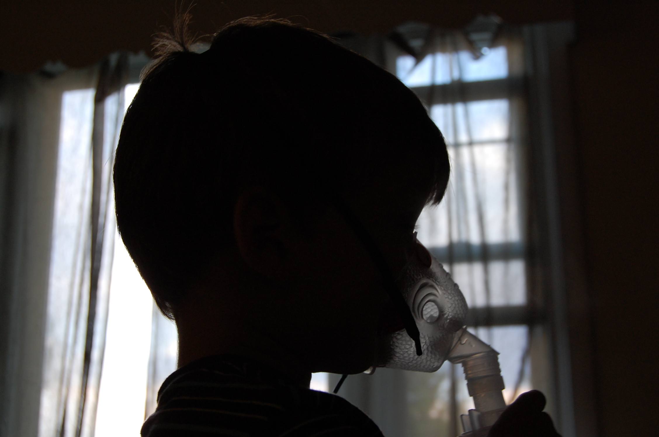Silhouette of child with asthma mask